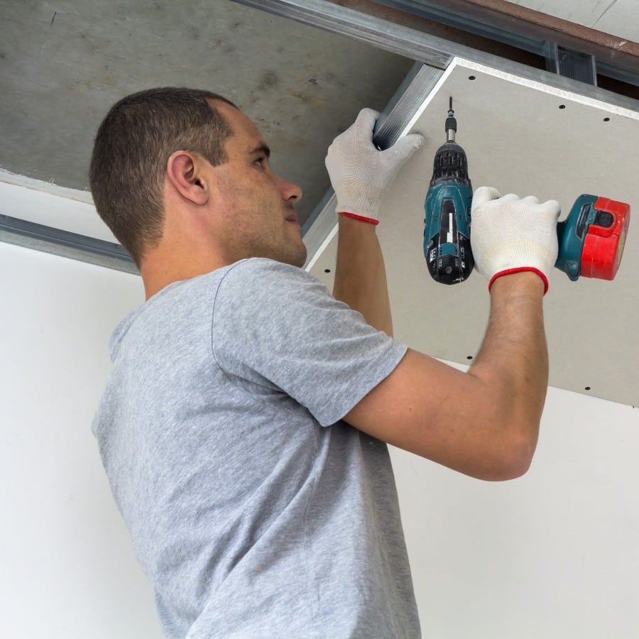 construction worker assemble a suspended ceiling with drywall