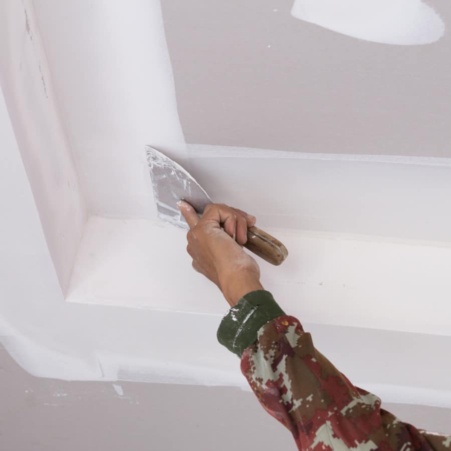 hand of worker using gypsum plaster ceiling joints